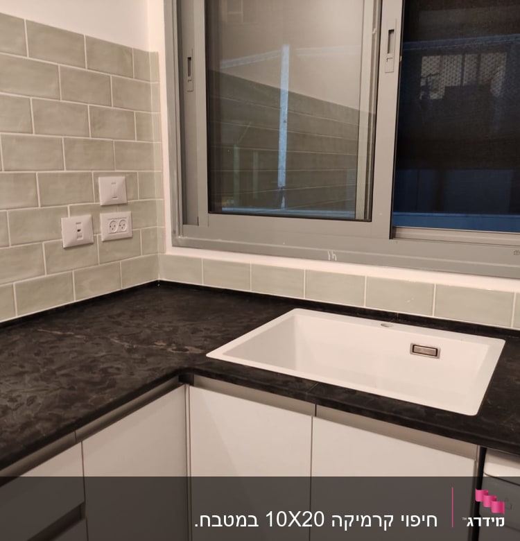 מטבח משופץ עם כיור חדש ומשטח עבודה כהה